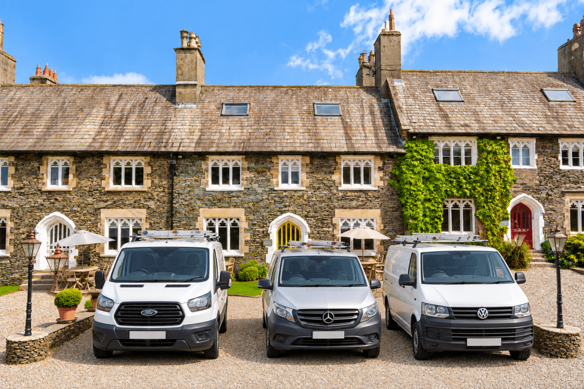 Three work vans parked outside a Terrace Windermere holiday house near Windermere, available for midweek team bookings